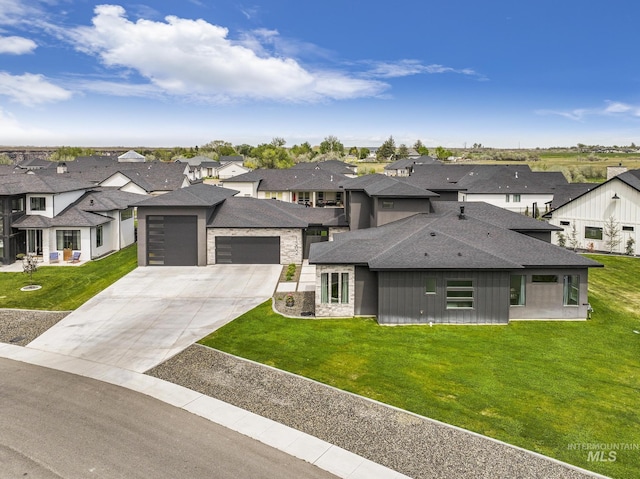 prairie-style home with an attached garage, driveway, a residential view, and a front lawn