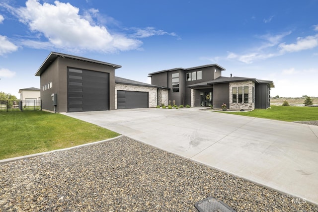 view of front of house featuring a garage, concrete driveway, stucco siding, fence, and a front yard