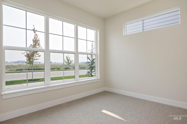 unfurnished room featuring carpet floors and baseboards