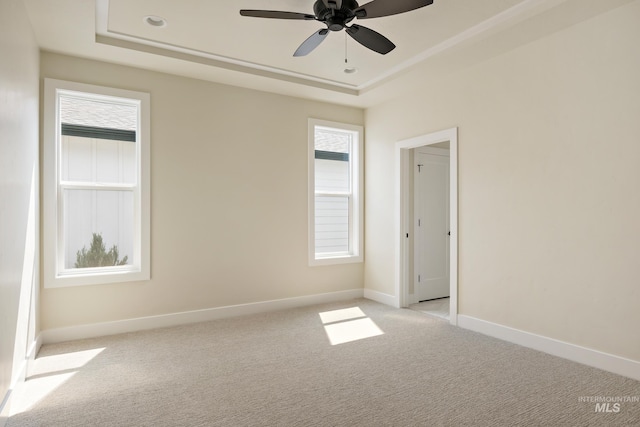 unfurnished room featuring baseboards, ceiling fan, a raised ceiling, and light colored carpet