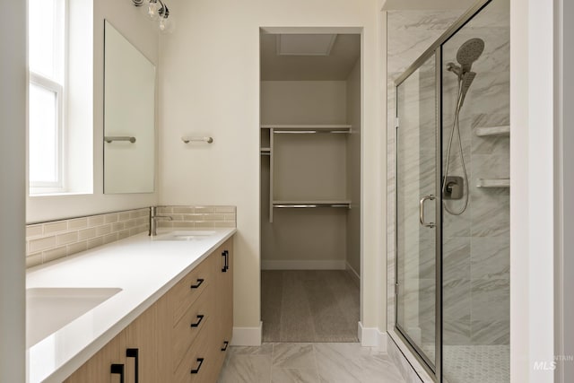 full bathroom featuring a sink, a walk in closet, and a shower stall