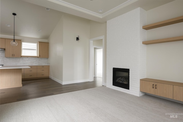 unfurnished living room featuring baseboards, dark wood-style floors, vaulted ceiling, dark colored carpet, and a fireplace