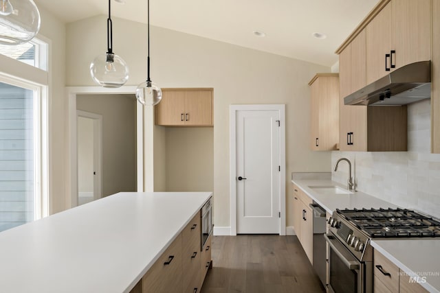 kitchen with light countertops, appliances with stainless steel finishes, light brown cabinets, a sink, and under cabinet range hood