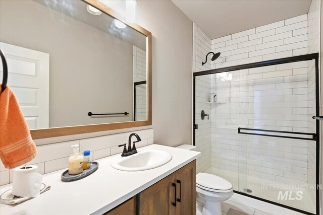 3303 S Island Fox Ave, Eagle, ID 83616 - bathroom featuring a stall shower, toilet, backsplash, and vanity