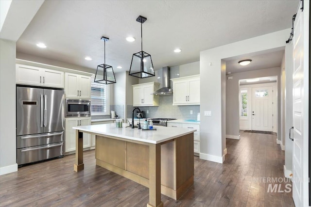 3303 S Island Fox Ave, Eagle, ID 83616 - kitchen featuring appliances with stainless steel finishes, wall chimney exhaust hood, a sink, tasteful backsplash, and light countertops