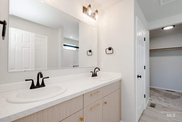 full bath featuring visible vents, double vanity, and a sink
