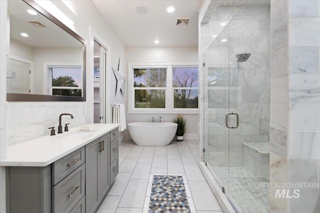 bathroom with vanity, tasteful backsplash, and separate shower and tub