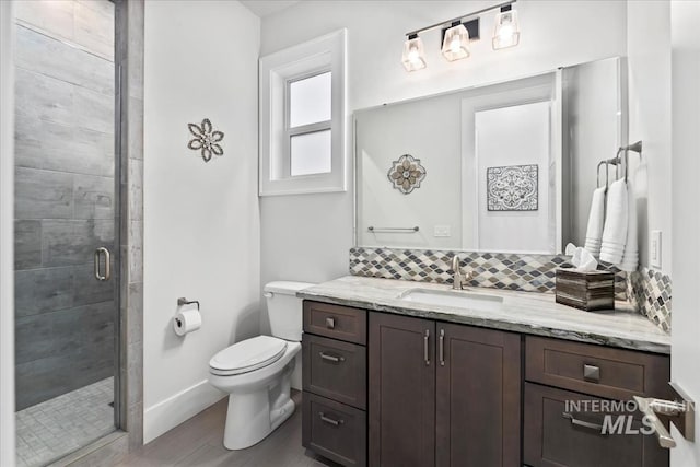 bathroom with hardwood / wood-style floors, vanity, an enclosed shower, tasteful backsplash, and toilet