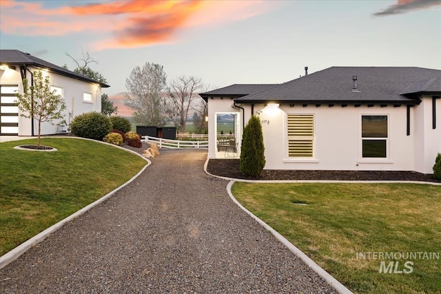 property exterior at dusk with a yard