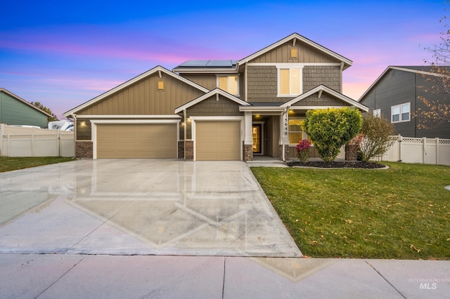 craftsman-style home featuring a garage, a lawn, and solar panels