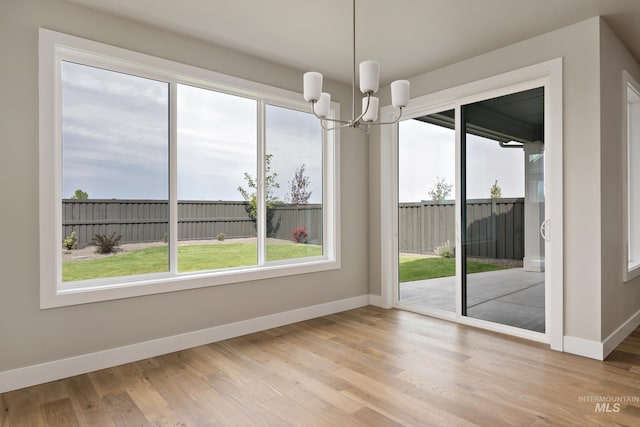 7017 S Zenith Ave, Meridian, ID 83642 - unfurnished dining area with baseboards, a notable chandelier, and light wood-style floors