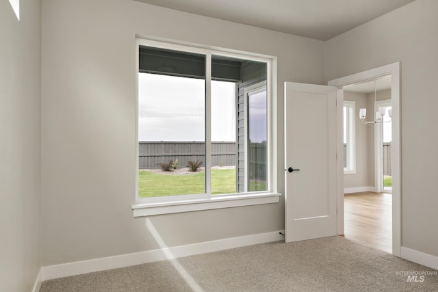 7017 S Zenith Ave, Meridian, ID 83642 - carpeted spare room with baseboards and an inviting chandelier