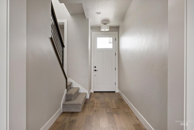 7017 S Zenith Ave, Meridian, ID 83642 - entryway featuring light wood-style flooring, baseboards, and stairway