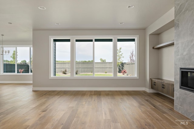 7017 S Zenith Ave, Meridian, ID 83642 - unfurnished living room featuring a tile fireplace, light wood finished floors, baseboards, and recessed lighting