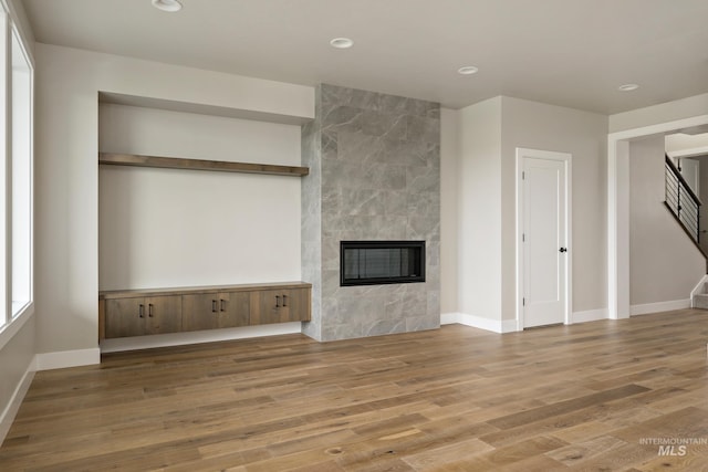 7017 S Zenith Ave, Meridian, ID 83642 - unfurnished living room with baseboards, a fireplace, recessed lighting, stairway, and wood finished floors