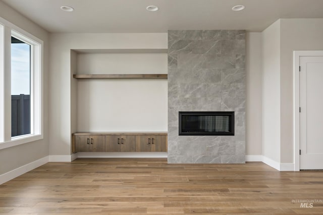 7017 S Zenith Ave, Meridian, ID 83642 - unfurnished living room featuring baseboards, recessed lighting, a tile fireplace, and wood finished floors