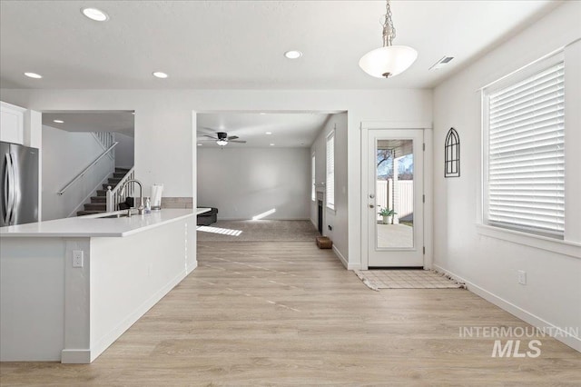 kitchen with white cabinetry, sink, a healthy amount of sunlight, and pendant lighting