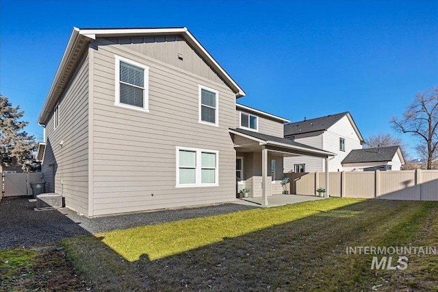 back of property featuring a patio area and a lawn