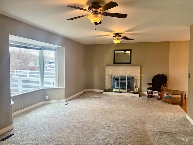 unfurnished living room with carpet floors, visible vents, a fireplace, and baseboards