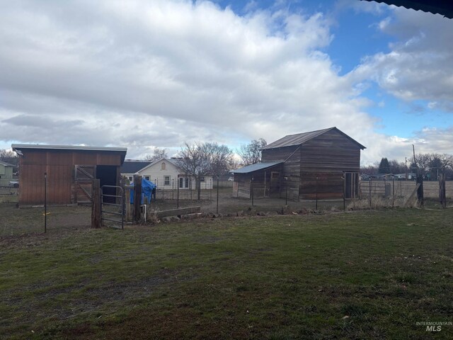 view of yard with fence and an outbuilding