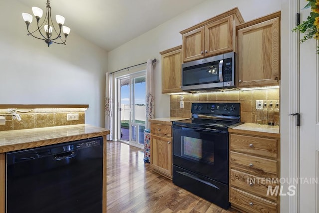 741 Gregory Way, Twin Falls, ID 83301 - kitchen with black appliances, backsplash, wood finished floors, light countertops, and a chandelier