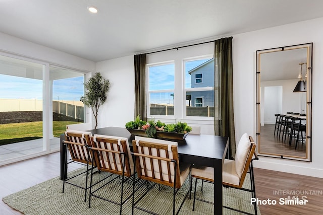 dining area with baseboards, plenty of natural light, recessed lighting, and wood finished floors