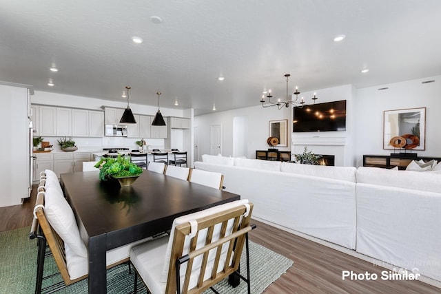 dining area featuring an inviting chandelier, recessed lighting, and wood finished floors