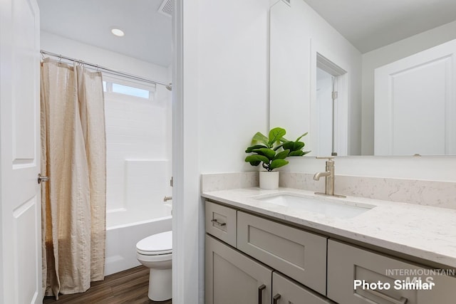 bathroom with vanity, shower / bath combo, toilet, and wood finished floors