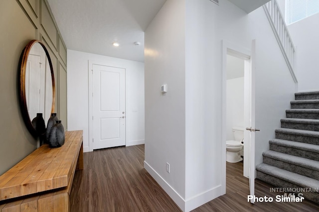 corridor with recessed lighting, baseboards, dark wood finished floors, and stairs