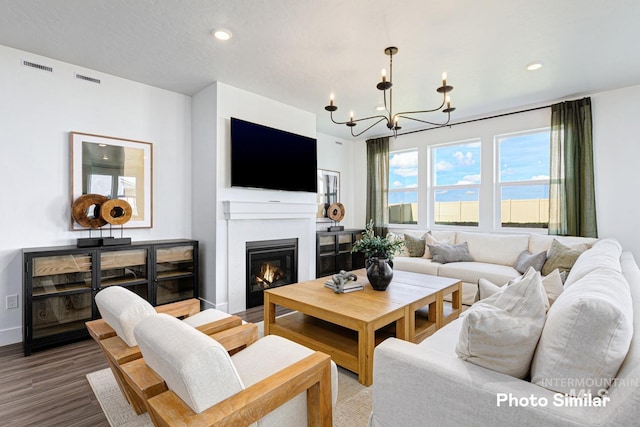 living room with an inviting chandelier, recessed lighting, wood finished floors, and visible vents
