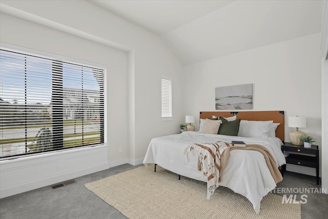 carpeted bedroom with vaulted ceiling, visible vents, and baseboards