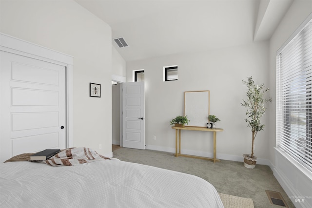 carpeted bedroom with lofted ceiling, baseboards, and visible vents