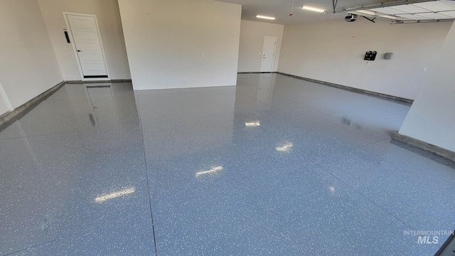 garage featuring a garage door opener and baseboards