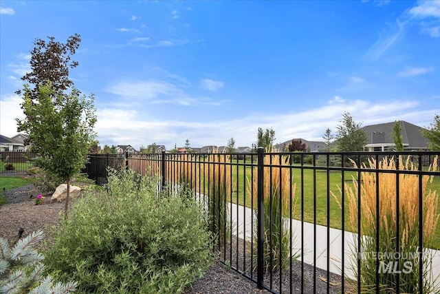 view of gate featuring a lawn and fence