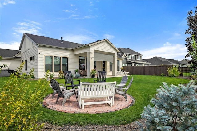 back of house featuring a yard, fence, board and batten siding, and a patio