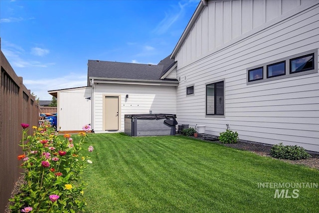 view of yard with fence and a hot tub