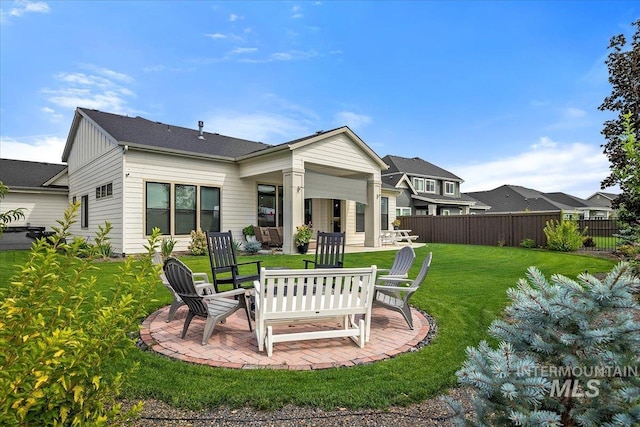 back of property featuring a yard, board and batten siding, a patio area, and fence