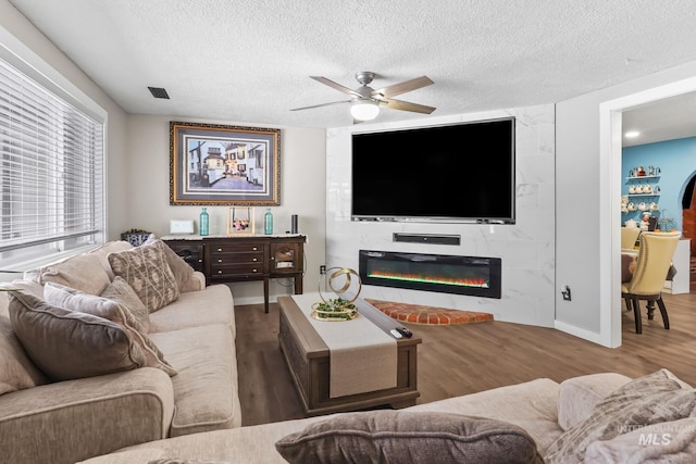 15201 Christopher, Caldwell, ID 83607 - living area with a textured ceiling, wood finished floors, a ceiling fan, a large fireplace, and baseboards