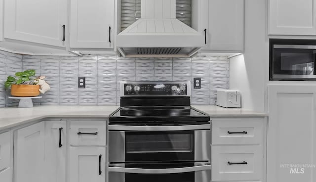 15201 Christopher, Caldwell, ID 83607 - kitchen with range with two ovens, premium range hood, white cabinetry, tasteful backsplash, and light countertops