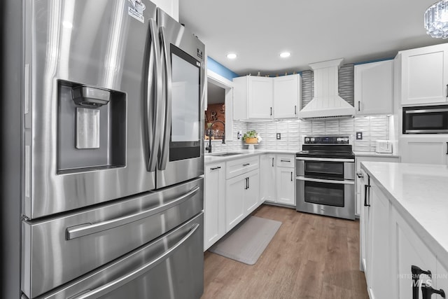 15201 Christopher, Caldwell, ID 83607 - kitchen featuring stainless steel appliances, premium range hood, a sink, white cabinets, and wood finished floors