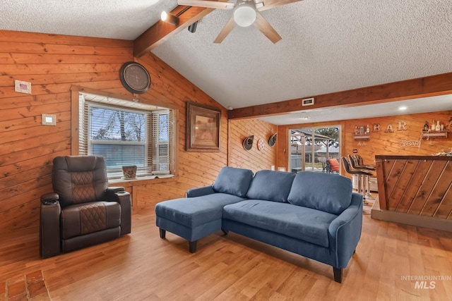 15201 Christopher, Caldwell, ID 83607 - living room featuring wood walls, a textured ceiling, light wood-style floors, and a ceiling fan