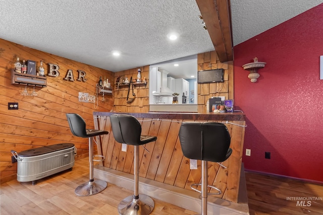 15201 Christopher, Caldwell, ID 83607 - indoor dry bar with wall chimney exhaust hood, wood finished floors, a textured ceiling, wooden walls, and recessed lighting