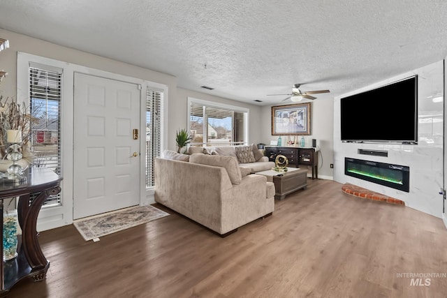 15201 Christopher, Caldwell, ID 83607 - living room with wood finished floors, ceiling fan, a textured ceiling, a glass covered fireplace, and baseboards