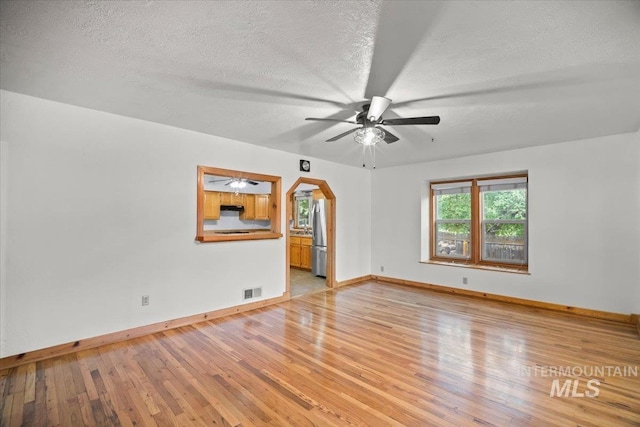 4523 N Mountain View Dr, Boise, ID 83704 - spare room with ceiling fan, light wood finished floors, a textured ceiling, and arched walkways