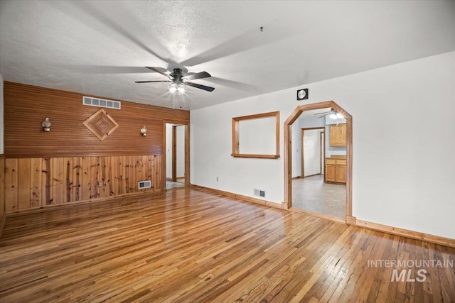 4523 N Mountain View Dr, Boise, ID 83704 - unfurnished living room featuring ceiling fan, wood walls, and light wood-style flooring