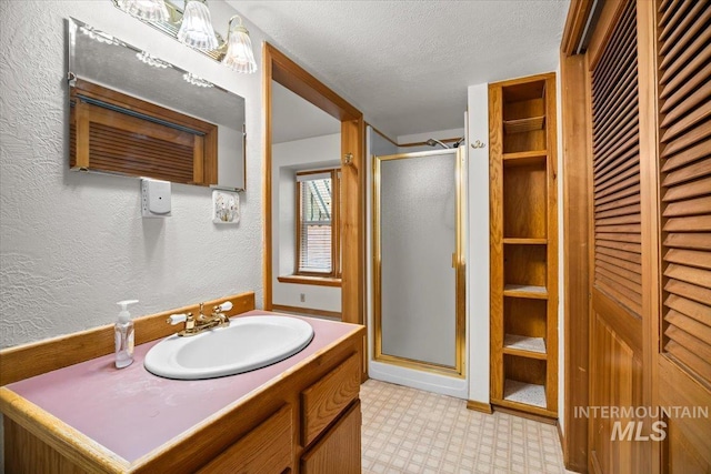 4523 N Mountain View Dr, Boise, ID 83704 - bathroom with tile patterned floors, a shower stall, vanity, a closet, and a textured wall