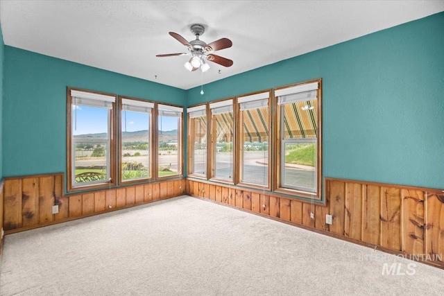 4523 N Mountain View Dr, Boise, ID 83704 - carpeted spare room featuring wooden walls, ceiling fan, and a wainscoted wall