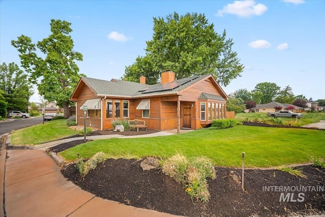4523 N Mountain View Dr, Boise, ID 83704 - view of front of home with solar panels, a chimney, a front yard, and a shingled roof