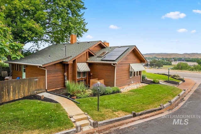 4523 N Mountain View Dr, Boise, ID 83704 - chalet / cabin with a chimney, solar panels, and a shingled roof