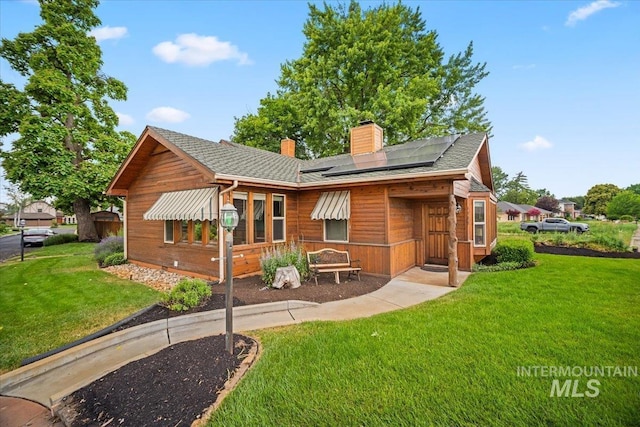 4523 N Mountain View Dr, Boise, ID 83704 - back of house with a chimney, solar panels, a yard, and roof with shingles